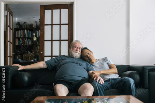 Portrait of Loving Retired Senior Gay Couple Sitting Together at Home