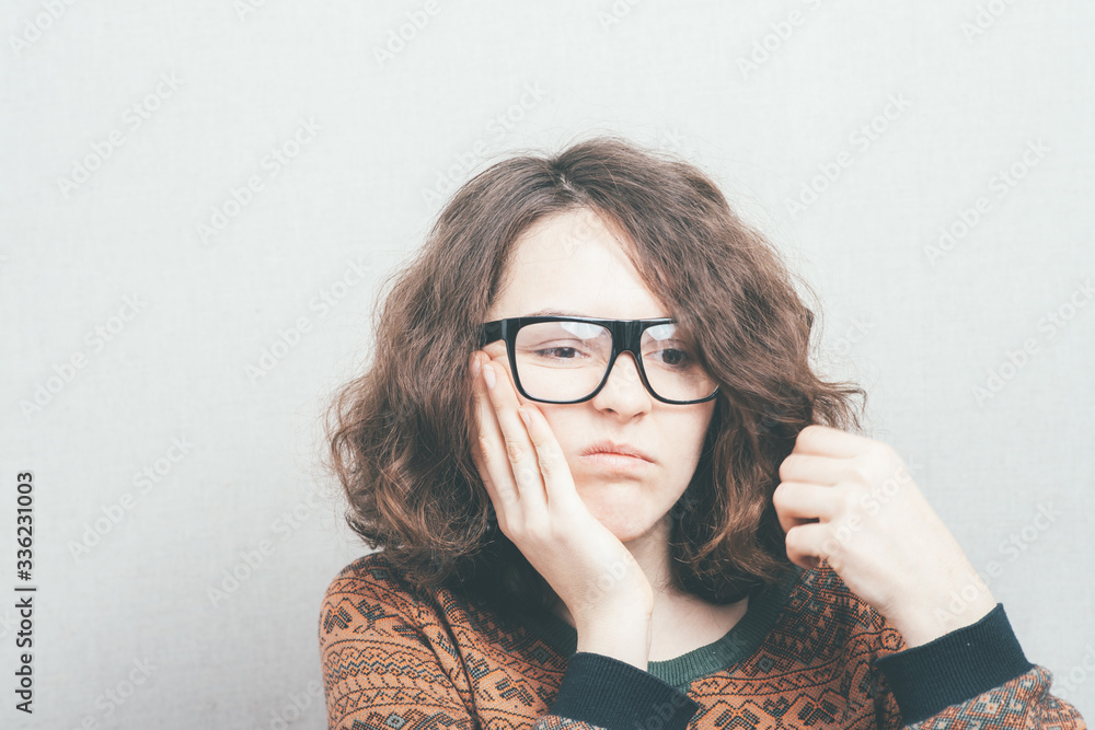 Girl has a toothache wearing glasses