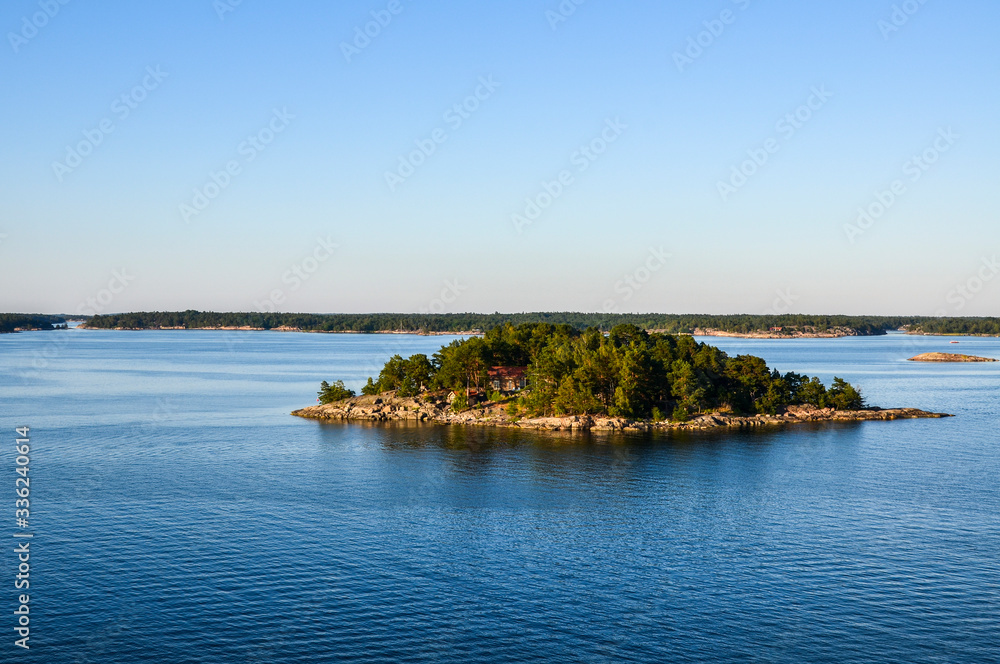 Houses and cottages in quiet Stockholm Archipelago with colorful trees, in Baltic sea at sunny morning, Sweden 