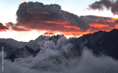 Sunset and Fiery Sky over Foggy Himalayan Mountain Peaks