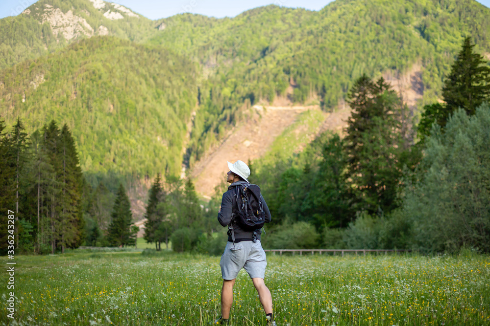Man hiking in forest. Male hiker looking at beautiful green nature and wilderness.