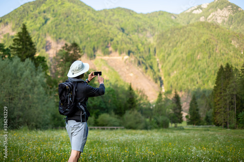 Young Man hiker Taking Photos Of Landscape With Mobile Smart Phone