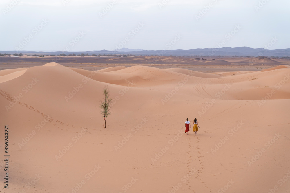 Two young women walking in Sahara Desert, Merzouga, Morocco Two young women walking in Sahara Desert, Merzouga, Morocco