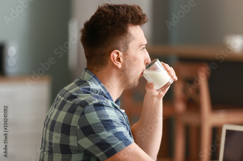 Young man drinking milk in ...