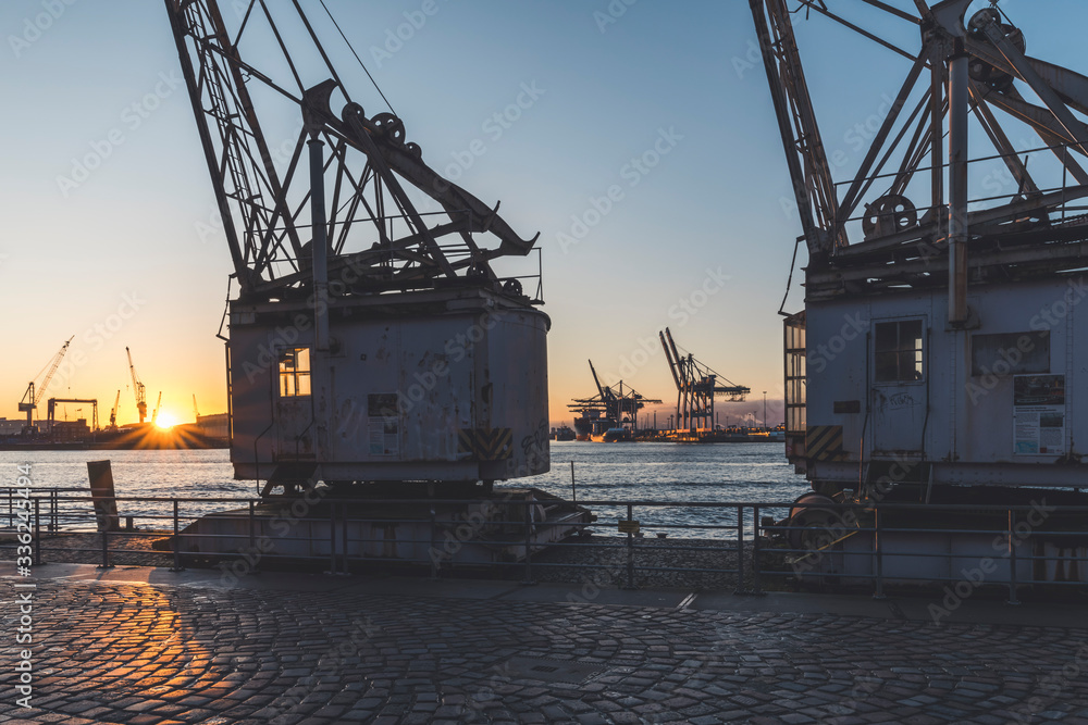 Germany, Hamburg, Old harbor cranes on bank of Elbe at sunset Germany, Hamburg, Old harbor cranes on bank of Elbe at sunset