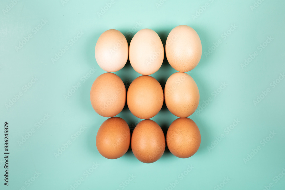 Organic chicken Eggs with copy space on mint background. Flat lay style.