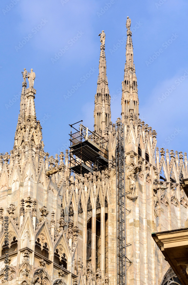 Cathedral of the Nativity of the Virgin Mary in Milan. Cathedral of white marble. The Late Gothic building contains many spiers and sculptures, marble peaked towers and columns.