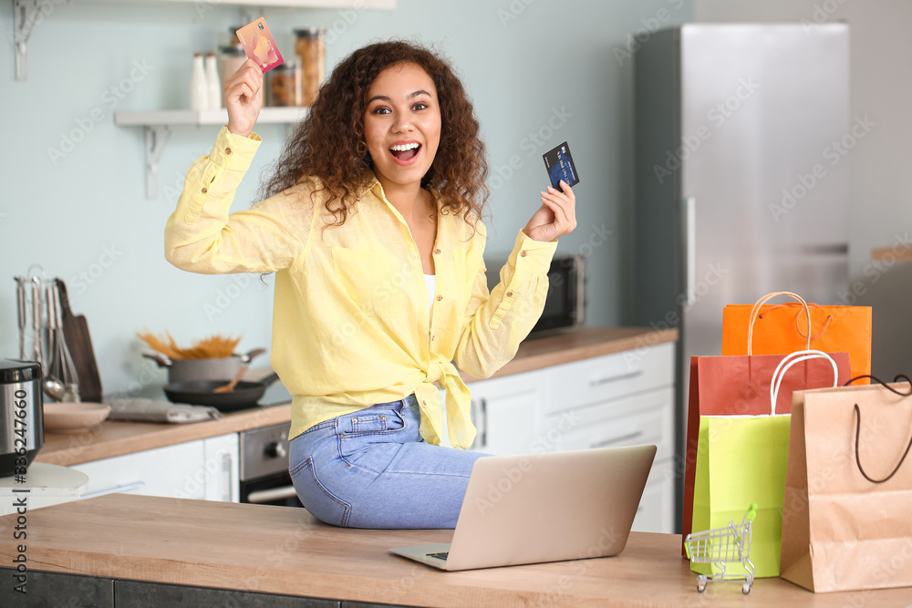 Happy woman with laptop, credit cards and shopping bags at home Happy woman with laptop, credit cards and shopping bags at home