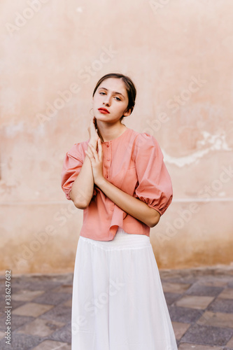 Portrait of teenage girl wearing pink blouse and white culottes photo