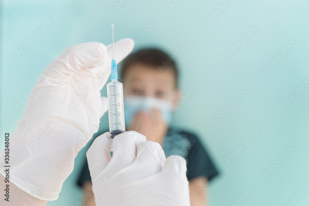 hands in white medical gloves hold syringe with medicine in it, prepare for injection of vaccine, child in medical mask on background not in focus look with fear, scared of vaccination from viruses hands in white medical gloves hold syringe with medicine in it, prepare for injection of vaccine, child in medical mask on background not in focus look with fear, scared of vaccination from viruses