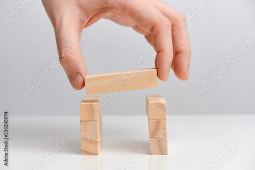 Business combination concept.. Hand holds wooden blocks on a white background.