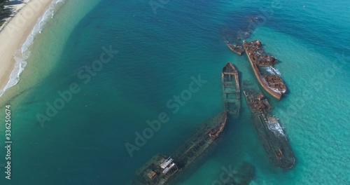 Wide shot of ship wrecks off a beautiful island shot in 4k