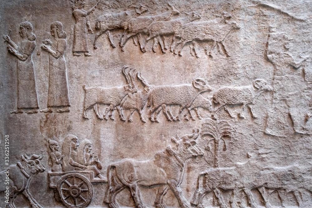 Ancient persian bas-relief depicting people and livestock