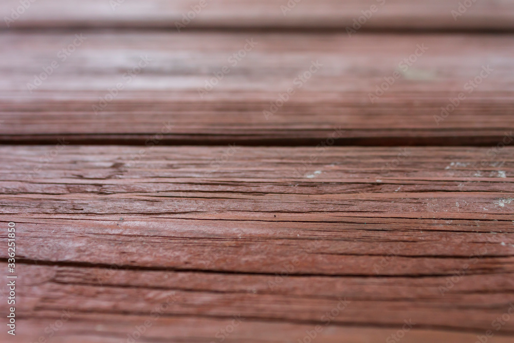 Wood grains showing through fading brown weathered paint on pitch pine boards Wood grains showing through fading brown weathered paint on pitch pine boards