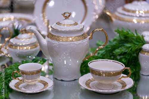 Arrangement of a luxury porcelain dinnerware with golden hand painted. Interior elemen with design hand painted with gold. Luxury antique style golden dinner set.