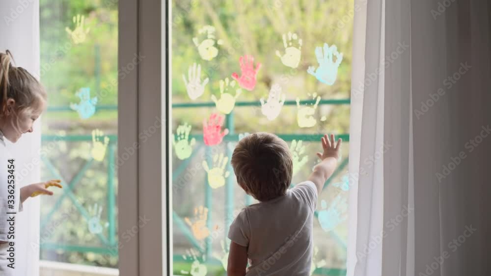 Children paint with palms on the window. Quarantine Stay at home Children paint with palms on the window. Quarantine Stay at home