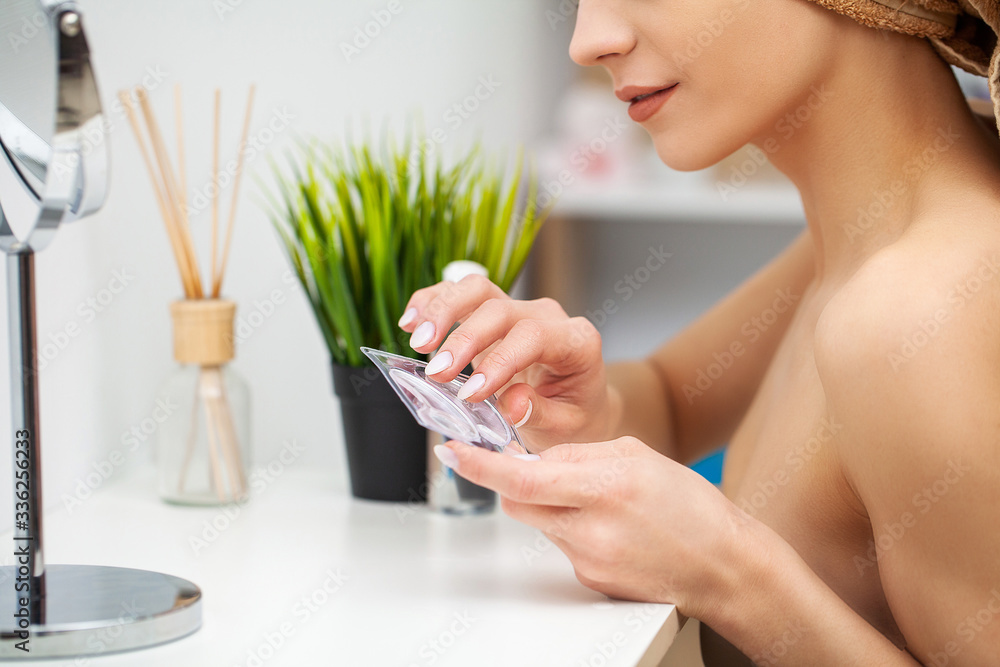 Cute woman in bathroom doing cosmetic procedure for facial skin care Cute woman in bathroom doing cosmetic procedure for facial skin care