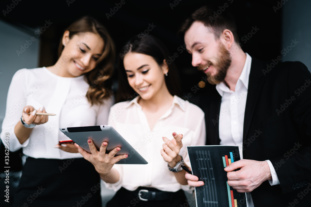 Coworkers looking at tablet screen at workplace Coworkers looking at tablet screen at workplace