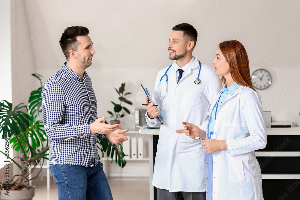 Obraz premium Doctors with patient in hall of clinic