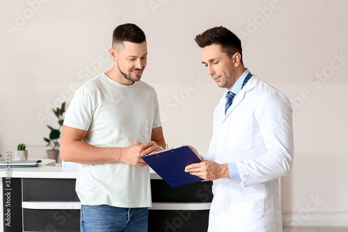 Male doctor with patient wo...