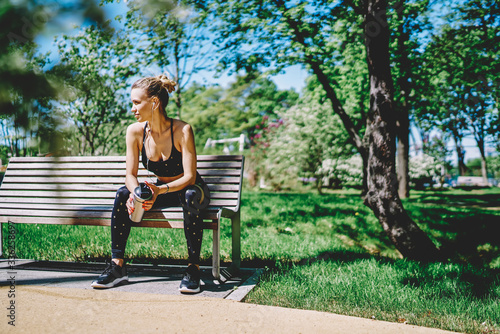 Sportive female sitting on bench in park