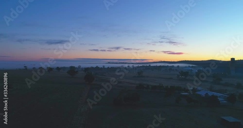 Dramatic 4K drone video of the sunrise over a farm on a foggy morning in New South Wales, Australia.