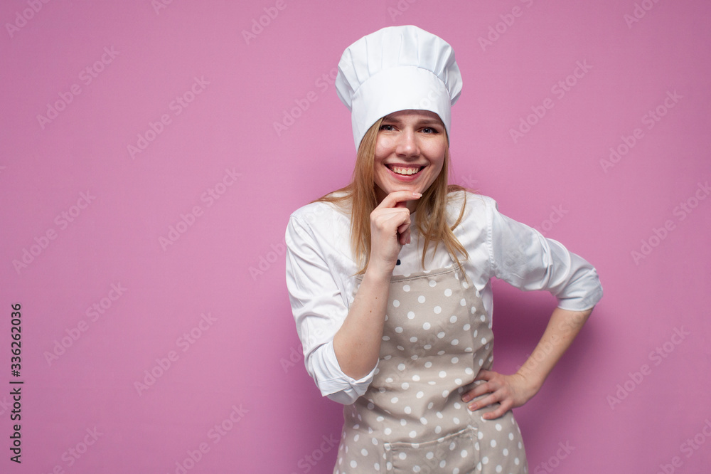 beautiful girl cook in uniform and apron on a colored pink background, portrait of a housewife woman in kitchen clothes beautiful girl cook in uniform and apron on a colored pink background, portrait of a housewife woman in kitchen clothes