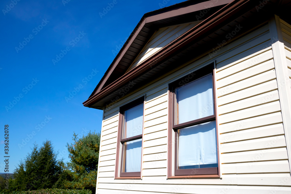 House with pale yellow vinyl siding House with pale yellow vinyl siding