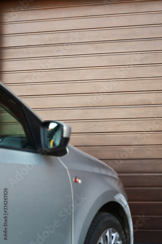 Front part of a car parked in front of the garage door. Selective focus.