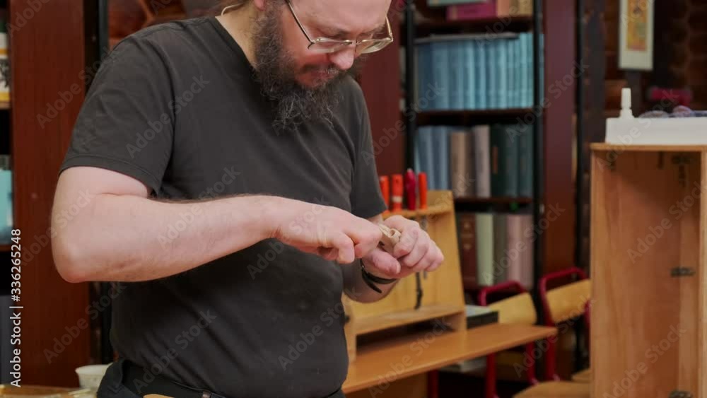 teacher with beard in glasses smiles and fixes aluminium detail in wooden airplane model engine at masterclass slow motion teacher with beard in glasses smiles and fixes aluminium detail in wooden airplane model engine at masterclass slow motion