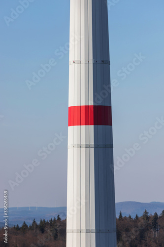 modern wind turbine column in front of the evening sun perpendicular