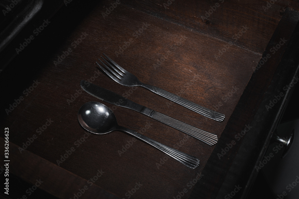 Minimalist set of silverware in an open kitchen drawer Minimalist set of silverware in an open kitchen drawer