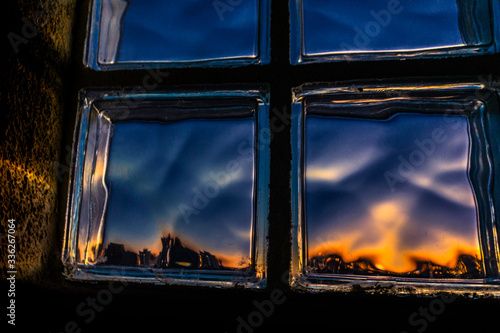 Distorted sunset view through square window.
