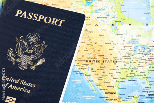 The foil-stamped dark blue front cover of an American passport set on a world map background.
