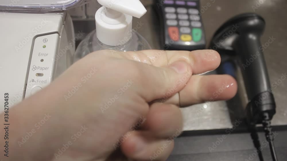 The seller in the store treats hands with an antiseptic. The seller in the store treats hands with an antiseptic.