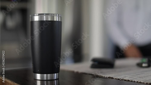 Man taking car key, wallet and tumbler with coffee out of table. Close up of hand taking tumbler with coffee to go in the kitchen. Slow motion.