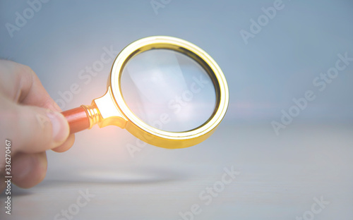 Business analytics and statistics. Businessman study report using a magnifying glass.