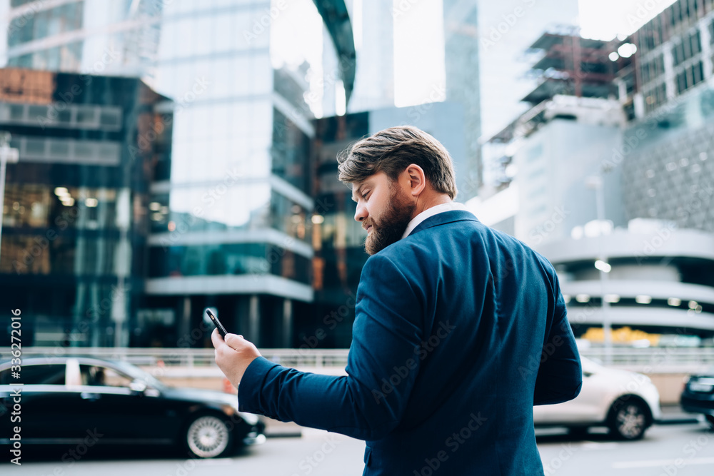 Man looking at phone on busy street