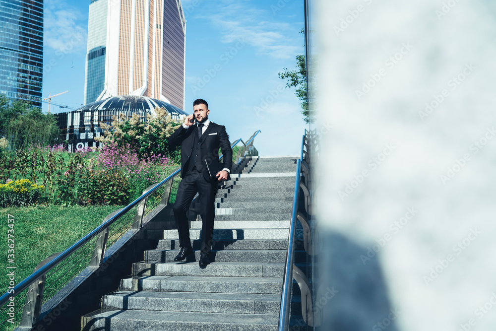 Businessman in suit descending stairs in city