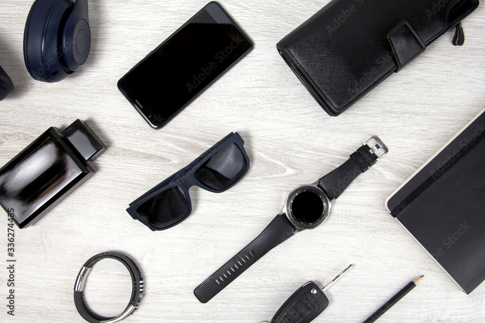 Background men's accessories lie on a wooden background. Black glasses, watch, notebook, wallet are on a light background. Objects close-up, top view Background men's accessories lie on a wooden background. Black glasses, watch, notebook, wallet are on a light background. Objects close-up, top view