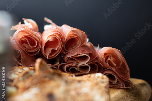 close up of prosciutto and crackers on a charcuterie meat board photo