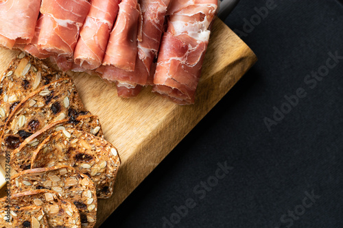 close up of prosciutto and crackers on a charcuterie meat board