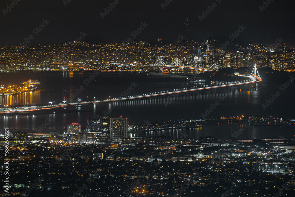 Bay Area California night view from Grizzly Peak. San Francisco, Oakland, Alameda, Berkeley, Bay Bridge and Sutro Tower. City skyline long exposure with water reflections.