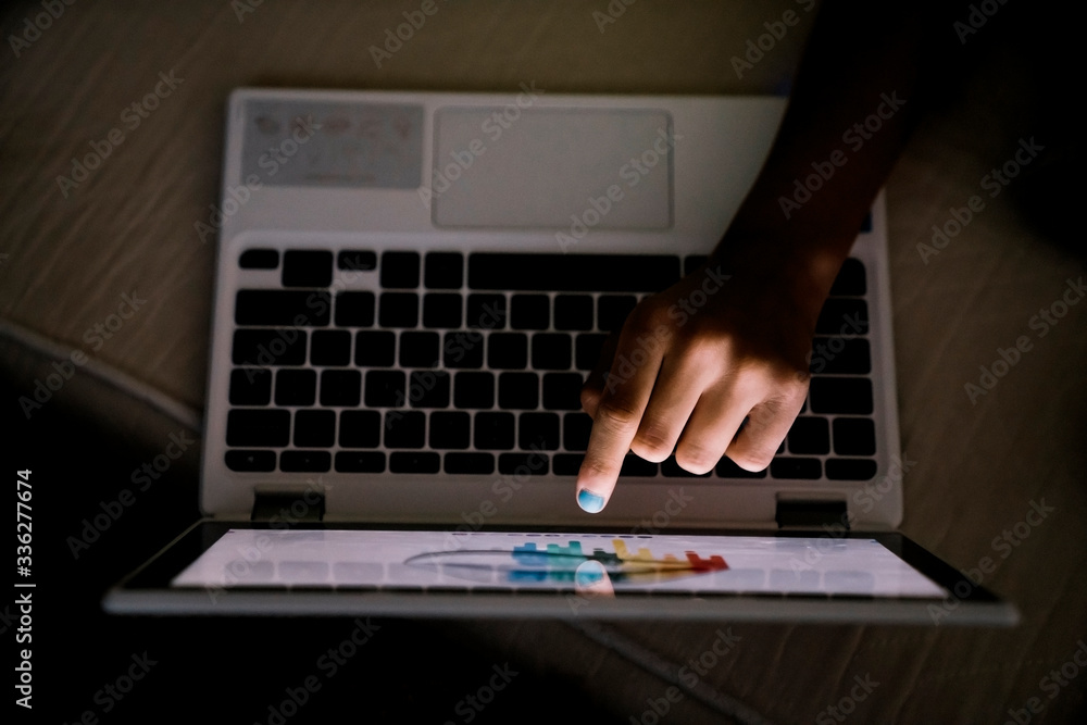 © Inti St. Clair - Girl creating art on touch screen laptop computer at night in the dark