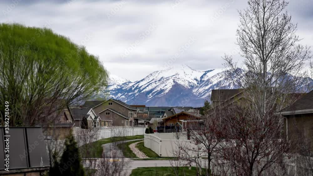 Overcast day in a suburban neighborhood with snow-capped mountains in the distance - zoom out time lapse Overcast day in a suburban neighborhood with snow-capped mountains in the distance - zoom out time lapse