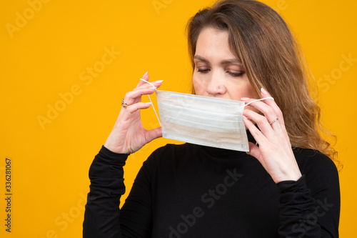 Woman holds a medical mask....