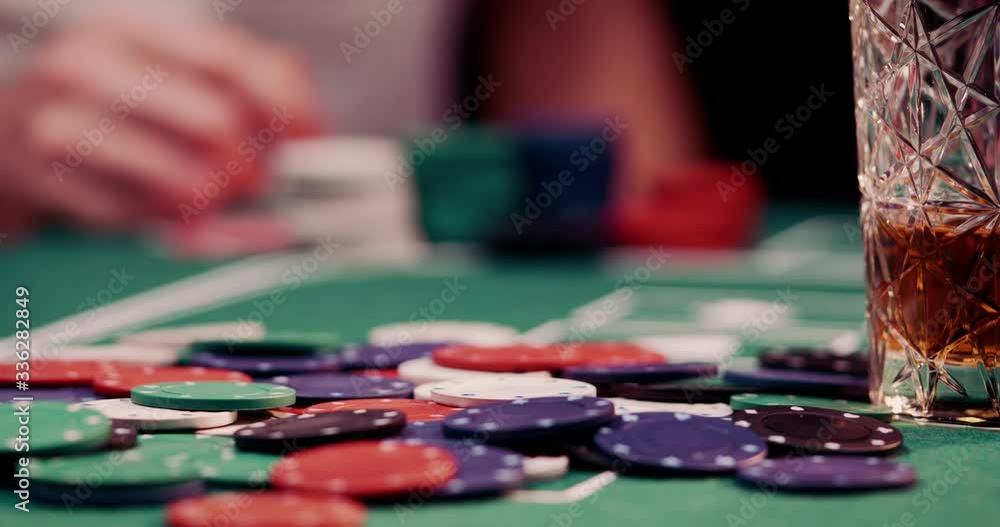Close up of poker chips got thrown by a gambler on a heap of chips in the middle of the poker table shot in 4k super slow motion Close up of poker chips got thrown by a gambler on a heap of chips in the middle of the poker table shot in 4k super slow motion