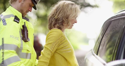 4K Policeman arresting a female driver & putting on the handcuffs. Slow motion.