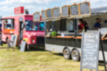 Food trucks and people at a street food market festival, blurred on purpose
