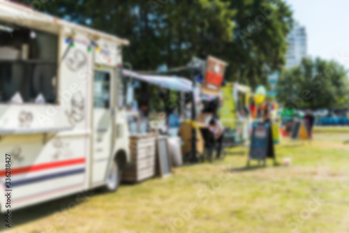 Food trucks and people at a street food market festival, blurred on purpose
